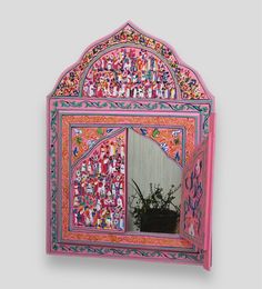 a pink mirror with colorful designs on it