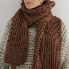 a woman wearing a brown knitted scarf