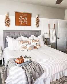 a bed with white and gray striped comforter in a bedroom next to a door