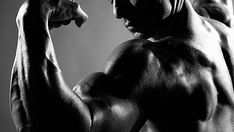 a black and white photo of a man flexing his muscles