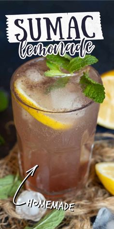 a close up of a drink in a glass with lemons and mint on the side