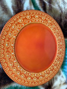 an orange plate with gold designs on it