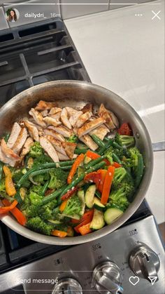 a pan filled with chicken and vegetables on top of a stove next to an oven