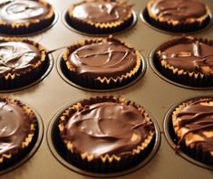 cupcakes with chocolate frosting sitting in a muffin tin