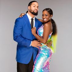 a man in a blue suit and woman in a colorful dress pose for the camera