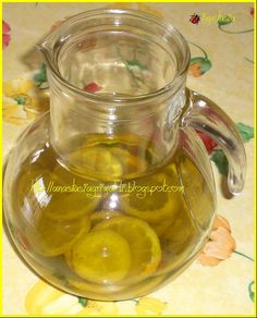 a pitcher filled with lemon slices on top of a table