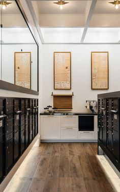 a large room with many mail boxes on the wall and two framed pictures above them