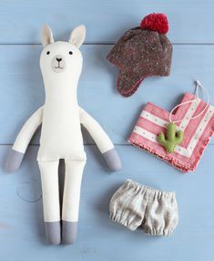 a stuffed animal and other items are laid out on a blue surface with wood planks