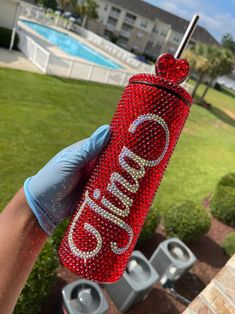 a person holding up a red bottle with the word gum on it