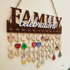 a family celebration sign hanging from the side of a wall with key chains attached to it