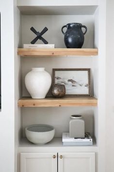 some shelves with vases and pictures on them