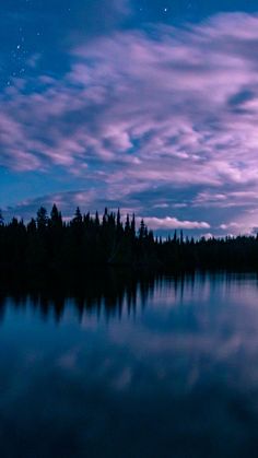 the night sky is reflected in the calm water