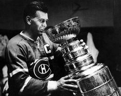 an old photo of a hockey player holding the stanleys cup in front of him