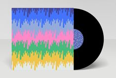 a black vinyl record with multicolored drips on the front and back cover