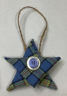 a blue plaid star ornament with a button on it