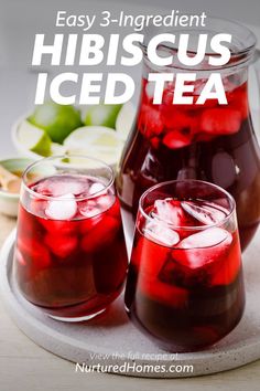 two glasses filled with red liquid and ice on top of a table next to an iced pitcher