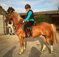 a woman riding on the back of a brown horse