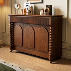 a wooden cabinet sitting on top of a hard wood floor next to a lamp and mirror