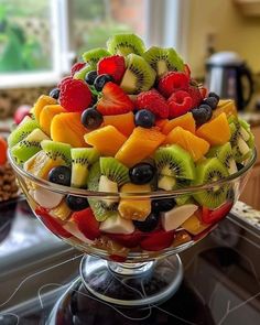 a fruit salad in a glass bowl on a kitchen counter