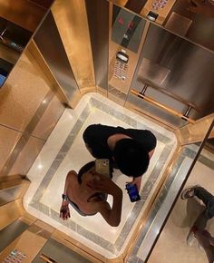 a woman is taking a selfie in the mirror on an elevator floor with her cell phone