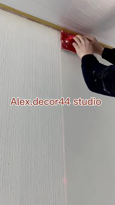 a person is painting the ceiling with white paint and red brush on top of it