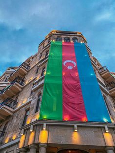 a very tall building with a large rainbow flag on it's front door and windows