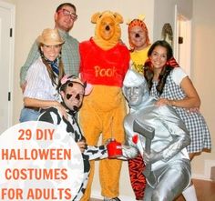 a group of people dressed up as winnie the pooh and friends posing for a photo