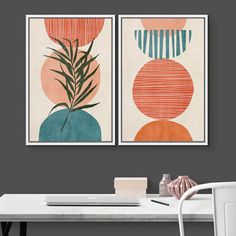 two art prints on the wall above a desk with a white chair and table in front of it