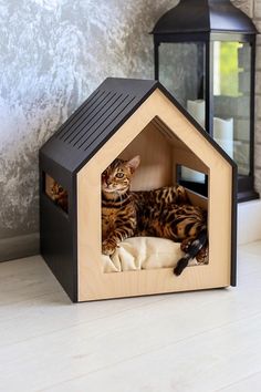 a cat laying in a small wooden house