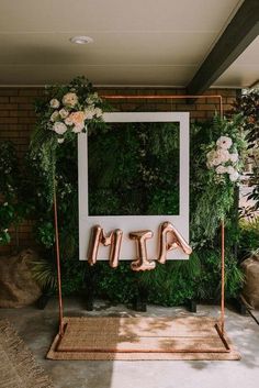 the entrance to an event with flowers and greenery