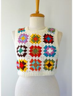 a white mannequin wearing a multicolored crochet top