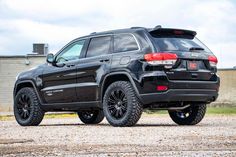 a black jeep is parked in front of a building