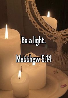 two white candles sitting on top of a plate with the words be a light mathew 51