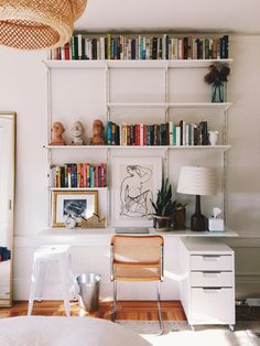 a room with bookshelves, desk and chair