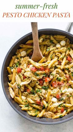 a skillet filled with pasta and chicken covered in pesto, cheese and tomatoes