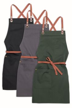 four colors of aprons with straps on each side and one is black, grey, green