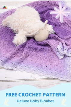 a crocheted blanket with a stuffed animal on it and the text free crochet pattern deluxe baby blanket