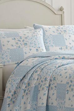 a bed with blue and white flowers on it
