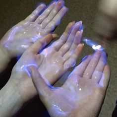 two hands that are covered in blue liquid