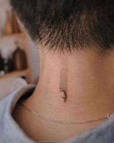 a man with a tiny bird tattoo on his neck