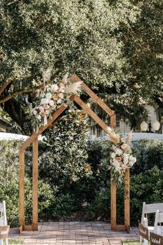 an outdoor ceremony setup with white flowers and greenery