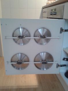 the door to an oven is open with four knobs