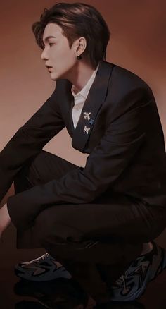 a young man sitting on top of a black and white photo