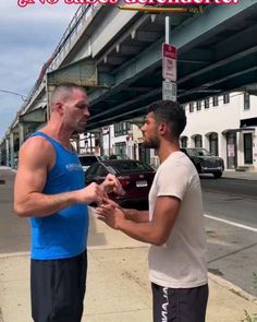 two men standing next to each other talking