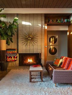 a living room filled with furniture and a fire place next to a wall mounted tv