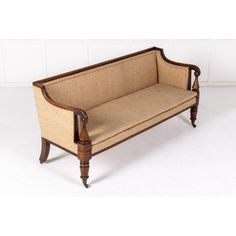 an old style couch with wooden legs and upholstered fabric on the armrests