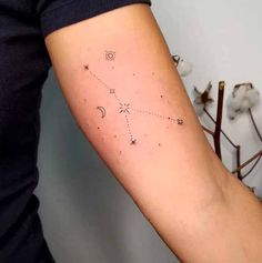 a woman's arm with a small star and moon tattoo on it