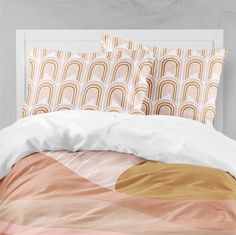 a bed with an orange, pink and white comforter