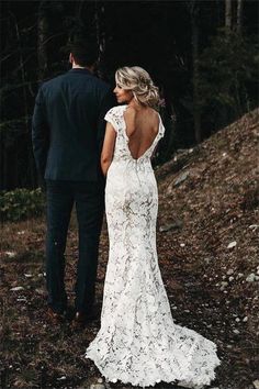 a bride and groom are walking in the woods with their back turned towards the camera