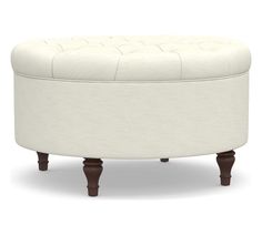 a white ottoman with wooden legs and an upholstered foot rest on the bottom